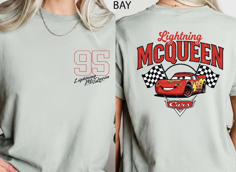 Puede incluir: Camiseta gris claro con el n&uacute;mero 95 en rojo en la parte delantera, con "Lightning McQueen" impreso debajo. La parte trasera muestra un gr&aacute;fico de Rayo McQueen con banderas a cuadros y el texto "Lightning McQueen Cars".
