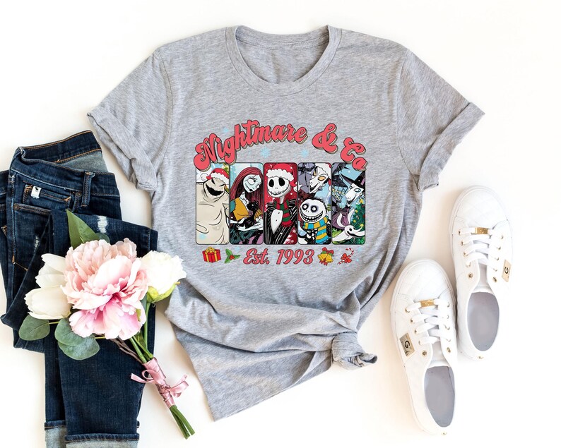 Puede incluir: Camiseta gris con un gr&aacute;fico de Pesadilla Antes de Navidad con Jack Skellington y otros personajes. El texto "Nightmare & Co. Est. 1993" est&aacute; impreso en la camiseta.