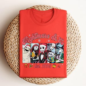 Puede incluir: Camiseta roja con un gr&aacute;fico de personajes de la pel&iacute;cula "Pesadilla antes de Navidad" con el texto "Nightmare & Co. Est. 1993".