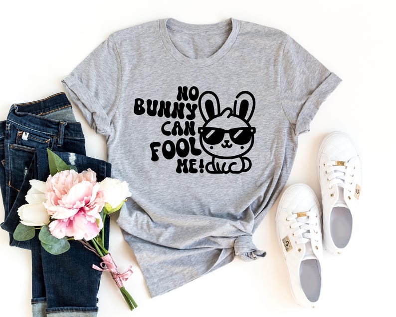 K&ouml;nnte beinhalten: Ein graues T-Shirt mit einer schwarzen Grafik eines Kaninchens mit Sonnenbrille und dem Text "No bunny can fool me!"