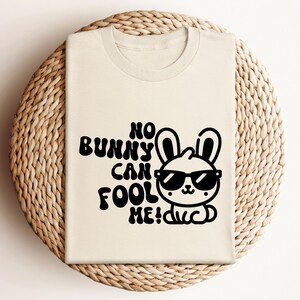K&ouml;nnte beinhalten: Ein wei&szlig;es T-Shirt mit einer schwarzen Grafik eines Kaninchens mit Sonnenbrille und dem Text "No bunny can fool me!"