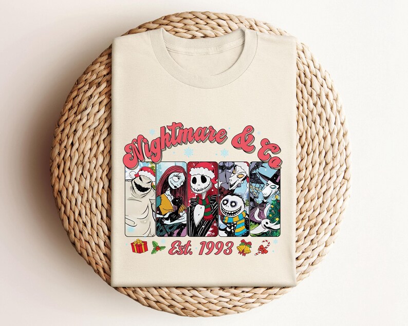 Puede incluir: Una camiseta blanca con un gr&aacute;fico colorido de personajes de la pel&iacute;cula Pesadilla antes de Navidad. El gr&aacute;fico incluye el texto "Nightmare & Co. Est. 1993".