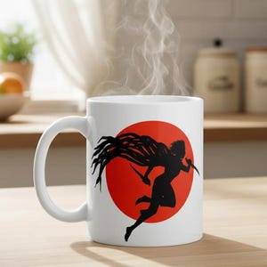 May include: White ceramic mug featuring a black silhouette of a running figure with flowing hair and two knives, set against a red circle. Steam rises from the mug, suggesting a hot beverage.