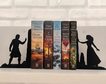 Fermalibri ispirati a Outlander, con una coppia davanti ad antiche pietre scozzesi – decorazioni delle Highlands scozzesi