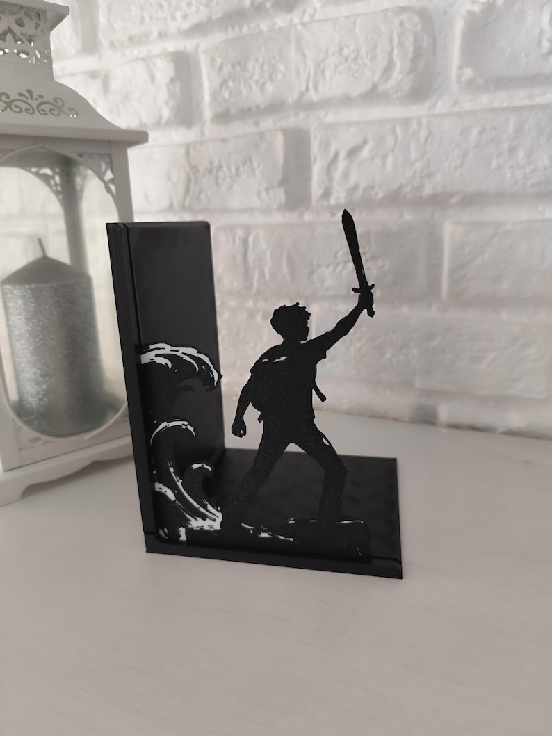Sujetalibros de metal con diseño de tridente y olas inspirado en mitología griega, decoración temática para estantería de libros juveniles y sagas de fantasía épica, accesorio decorativo de semidiós griego y dioses del Olimpo, regalo para lectores de novelas de aventuras y coleccionistas de BookTok.