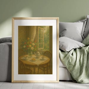 Op de afbeelding: Een ingelijste prent van een vintage interieurscène. Een ronde houten tafel is gedekt voor thee, met een theepot, kopjes en een bord met gebak. Een vaas met bloemen staat in de buurt en een raam met uitzicht bevindt zich op de achtergrond.