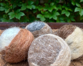 May include: Four felted wool balls in various colours and patterns. The balls are made of natural fibres and have a soft, fuzzy texture.