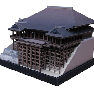 Puede incluir: Maqueta arquitectónica detallada de un templo japonés. El modelo presenta un tejado gris oscuro, soportes de madera marrón y una base de piedra gris claro. La estructura se asienta sobre una base negra, mostrando el intrincado diseño y la artesanía.