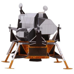 Op de afbeelding: Een gedetailleerd model van de Apollo Lunar Module, met een zwart, wit en goud kleurenschema. Het model heeft ingewikkelde geometrische panelen, antennes en landingsgestel. Het ruimtevaartuig is ontworpen om op de originele maanlander te lijken.