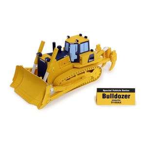 Può includere: Un modello di bulldozer Komatsu D155AX giallo con dettagli neri e blu. Il modello presenta una lama, cingoli e una cabina con finestre. Un cartello separato recita "Special Vehicle Series Bulldozer D155AX."