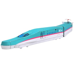 Könnte beinhalten: Modell eines japanischen Hochgeschwindigkeitszuges in Türkis mit einem weißen und rosa Streifen am unteren Rand. Der Zug hat ein stromlinienförmiges Design mit einer blauen Windschutzscheibe und detaillierten Fenstern. Das Modell steht vor weißem Hintergrund.