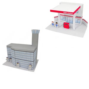 May include: A papercraft gas station and a multi-story building with miniature figures. The gas station has a red and white canopy with "GAS station" printed on it. The building has many windows and a tall smokestack.