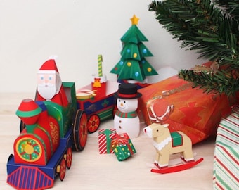 May include: A red and blue toy train with a Santa Claus figure in the front, a snowman, a reindeer, a Christmas tree, and a gift box. The train is made of paper and has a festive design.