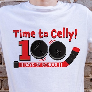 May include: White t-shirt with red text that says "Time to Celly! 100 Days of School!" with two black hockey pucks and a red hockey stick.