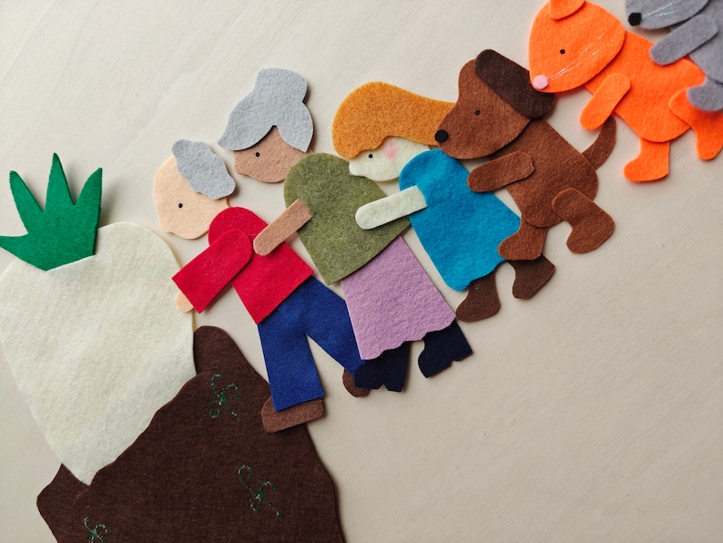 Puede incluir: Un conjunto de manualidades de fieltro que representa a los personajes del cuento infantil "El gran nabo". Los personajes incluyen un gran nabo blanco, un abuelo con el pelo verde, una abuela con el pelo rojo, un ni&ntilde;o con el pelo casta&ntilde;o, una ni&ntilde;a con el pelo rubio, un perro marr&oacute;n, un zorro y un gato.