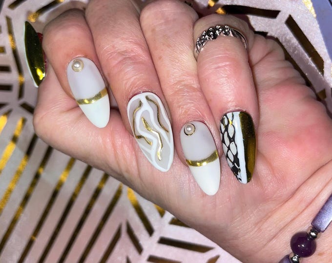 24 piece snake skin kit. Black, white and gold with pearls and sugar. Sizes from 0 to 11. Press-on nails, false nails, glue-on nails.