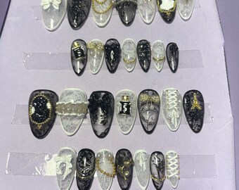 28-piece kit. Black and white lace with embellishments. Sizes 0 to 11. Reusable, press-on nails, false nails. Glossy finish