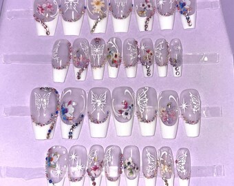 28-piece kit. White French nails with flower and butterfly patterns. Sizes 0 to 11. Reusable, press-on nails, false nails. Glossy finish