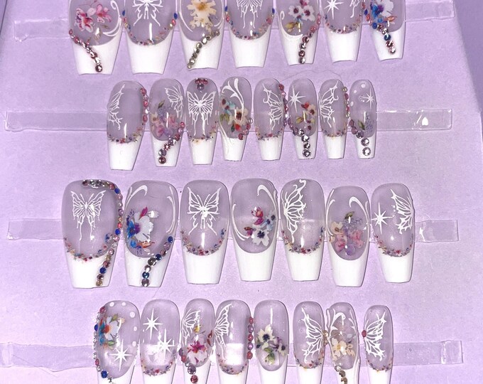 28-piece kit. White French nails with flower and butterfly patterns. Sizes 0 to 11. Reusable, press-on nails, false nails. Glossy finish