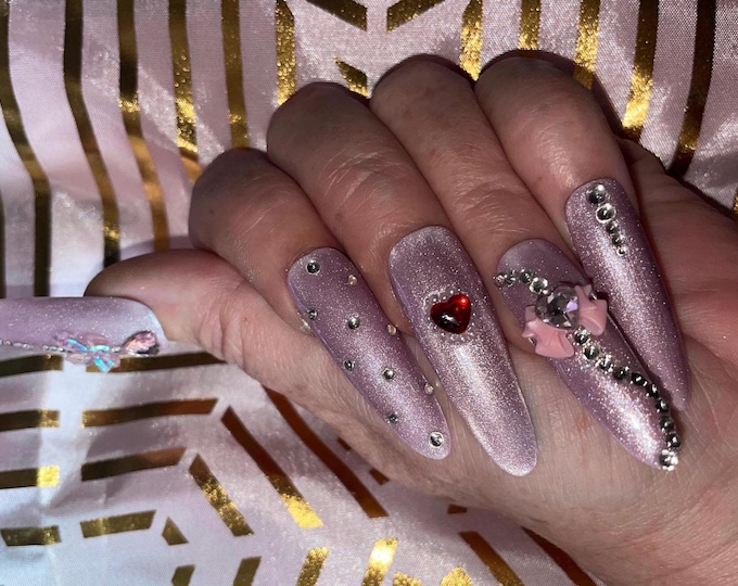 24 pieces. Pink cat eyes with rhinestones, small hearts, and bows. Sizes 0 to 9. Reusable. Press-on nails, false nails. Glossy finish.