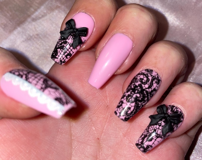 Kit 24 pieces. Black, white and pink lace. Rhinestones and bows. Sizes 0 to 9. False nails, press on nails. Reusable. Glossy finish.