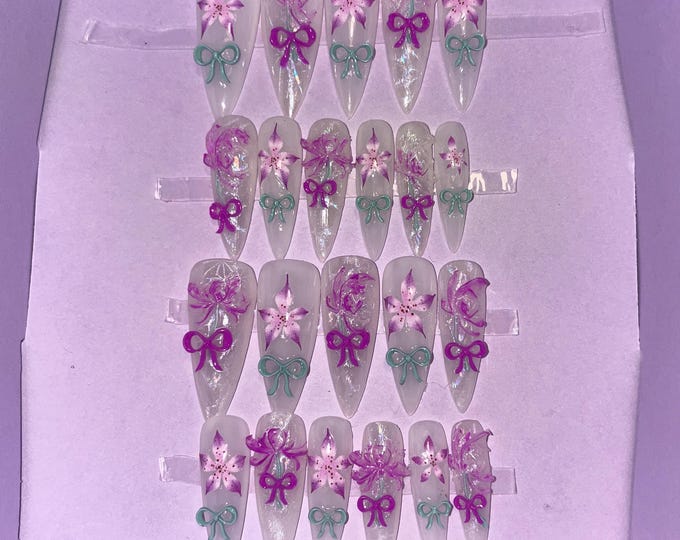 22-piece kit. Milky white with purple flowers and 3D green bows. Sizes 00 to 9. Reusable, press-on nails, false nails. Glossy finish
