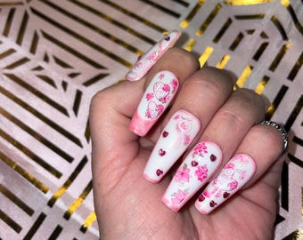 20-piece kit. Hearts, flowers, padlocks, and small heart rhinestones. Pink and white. Reusable. Press-on nails, false nails. Glossy finish.