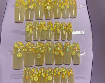 28-piece kit. Translucent yellow with lemon slices. Sizes 00 to 9. Reusable, press-on nails, false nails. Glossy finish