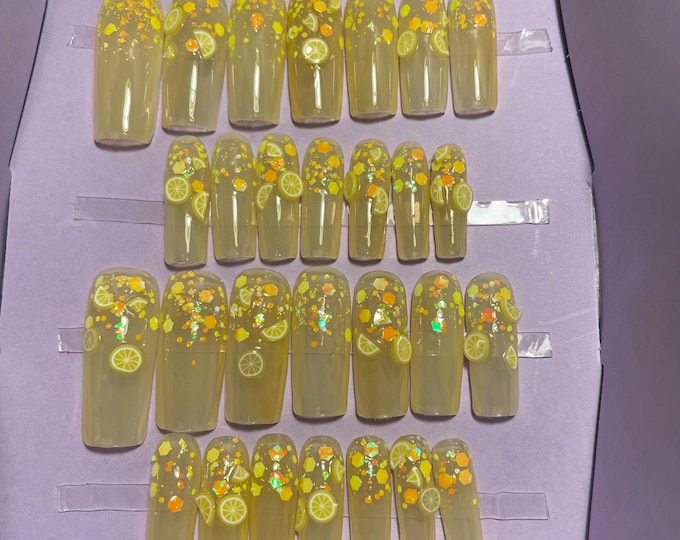 28-piece kit. Translucent yellow with lemon slices. Sizes 00 to 9. Reusable, press-on nails, false nails. Glossy finish