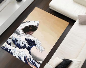 May include: A rug with a graphic design of a great white shark emerging from a large wave. The wave is blue and white, and the shark is white with a black outline. The background is a light beige color.