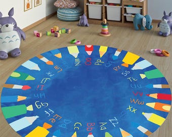 May include: A blue and yellow alphabet play mat with colorful crayons and paintbrushes around the edge. The letters of the alphabet are written in white around the edge of the mat.