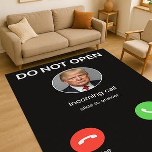 Puede incluir: Alfombra rectangular negra con diseño de pantalla de teléfono. Presenta un retrato, las palabras "DO NOT OPEN", "Incoming call" y el botón "Decline". También es visible un botón verde de respuesta. La alfombra está colocada sobre un suelo de madera.