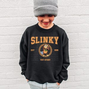 a young boy wearing a slinky sweatshirt and a hat