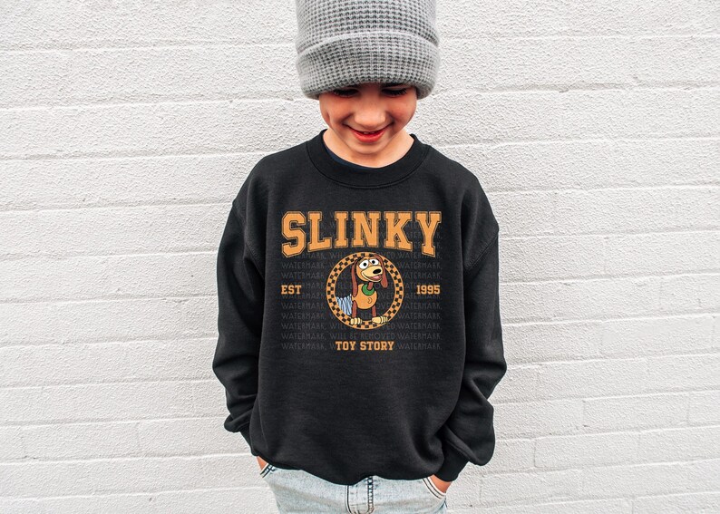 a young boy wearing a slinky sweatshirt and a hat