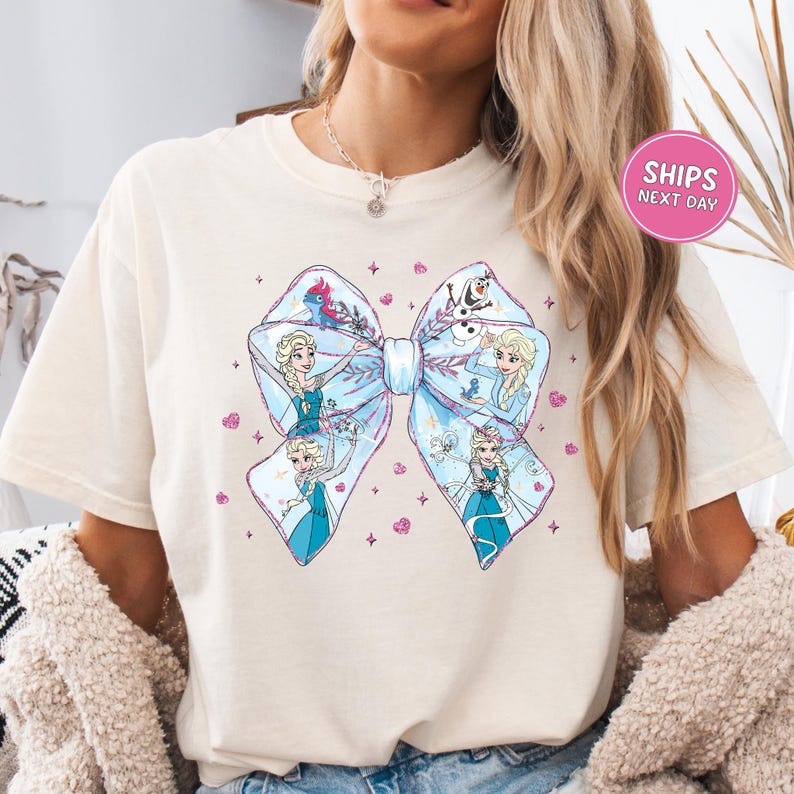 A woman wearing a white t-shirt with a large bow featuring characters from the Disney movie Frozen.