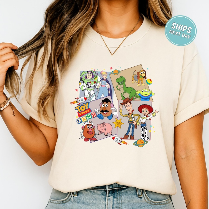 A person wearing a white t-shirt with a collage of various characters from the Toy Story franchise, including Buzz Lightyear, Woody, and other beloved characters.