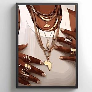 May include: A close-up of a person's hands wearing multiple gold rings and a layered gold necklace with a pendant shaped like the continent of Africa.