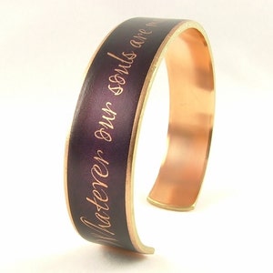 May include: A copper bracelet with a purple enamel band and gold lettering that reads "Master your own souls are m".