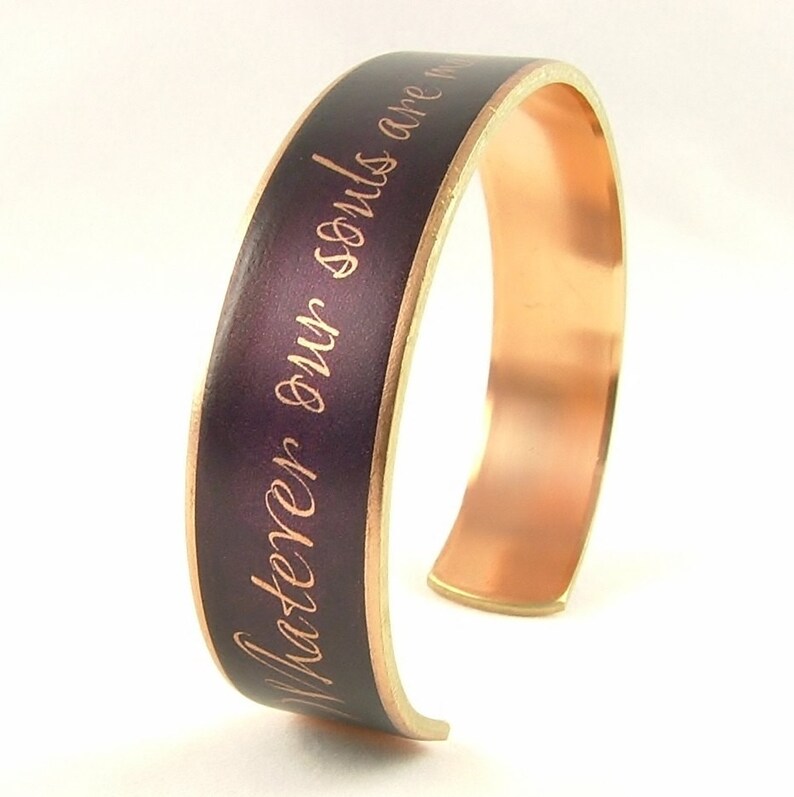 May include: A copper bracelet with a purple enamel band and gold lettering that reads "Master your own souls are m".