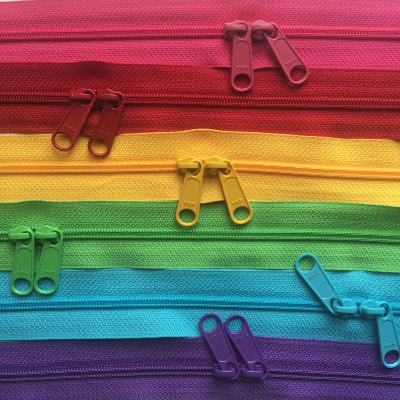 May include: A rainbow assortment of zipper tapes with YKK pull tabs. The zipper tapes are in the colors red, orange, yellow, green, blue, indigo, and violet.