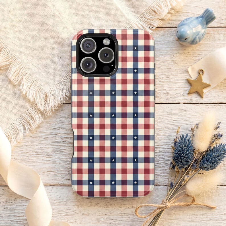 An iPhone case featuring a red white and blue plaid pattern with small star details in a classic Americana design. Ideal for a plaid patriotic iPhone case with preppy summer aesthetic.