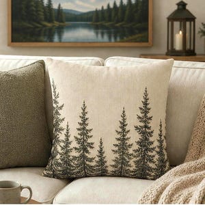 May include: A square throw cushion featuring a cream-coloured fabric base with a detailed black ink-style illustration of a dense forest of pine trees. The design covers the front surface, showcasing various heights of evergreen trees in a repeating pattern.