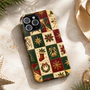 May include: A smartphone case featuring a grid pattern of festive holiday icons including poinsettias, bells, stockings, wreaths, and snowflakes in shades of deep red, forest green, and cream with gold accents.