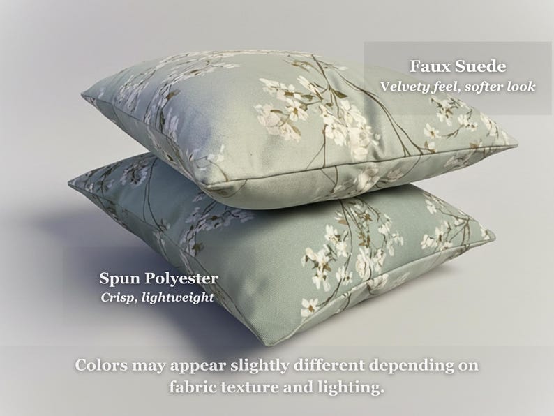 May include: Two decorative throw pillows stacked on top of each other. The pillows have a light green background with a white floral pattern. The top pillow is labeled "Faux Suede" and the bottom pillow is labeled "Spun Polyester".