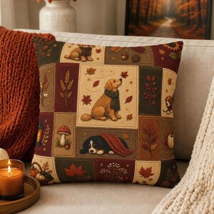 May include: A square throw pillow featuring a patchwork design with illustrations of dogs, autumn leaves, mushrooms, and a lantern. The color palette includes shades of brown, cream, dark green, and deep red, depicting seasonal motifs.