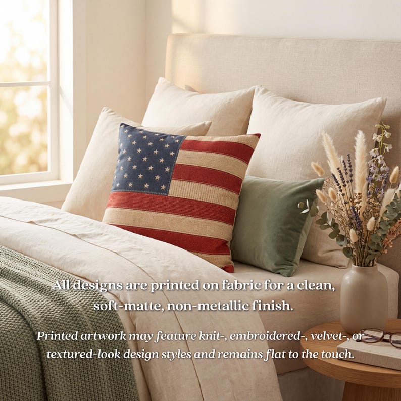May include: A bed with several pillows, including one with a design of the American flag. The flag pillow has a blue field with white stars and red and beige stripes. Other pillows are beige and green. A vase of dried flowers sits on the bedside table.