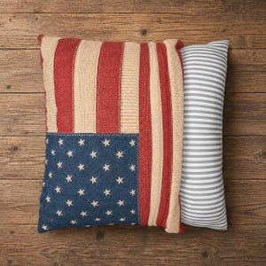 May include: Two decorative pillows on a wooden surface. One square pillow features a design resembling the American flag with red and beige stripes, a blue denim section with white stars. The second pillow is rectangular with gray and white stripes.