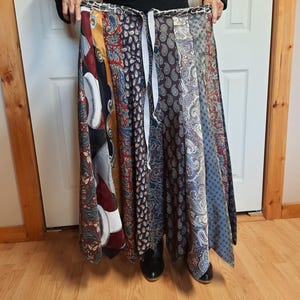May include: A long, flowing skirt made from a variety of patterned ties. The skirt is tied at the waist and has a flowing, A-line shape. The skirt is made from a variety of colors and patterns, including paisley, stripes, and solids.