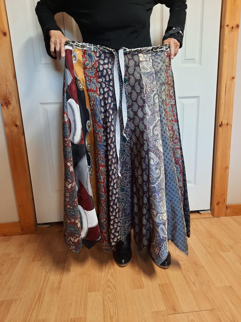 May include: A long, flowing skirt made from a variety of patterned ties. The skirt is tied at the waist and has a flowing, A-line shape. The skirt is made from a variety of colors and patterns, including paisley, stripes, and solids.