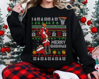 May include: Black sweatshirt with a festive design featuring a basketball-playing Santa Claus. The design includes a basketball hoop, Christmas trees, snowflakes, and the text "MERRY SWISHMAS". The sweatshirt is paired with red and black plaid pajama pants.